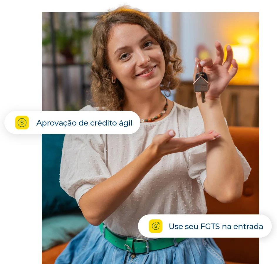 Mulher jovem e sorridente segurando as chaves de sua nova casa com chaveiro em formato de residência.